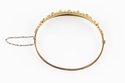 Lot 40 - An Edwardian gem set bangle, of hinged oval...