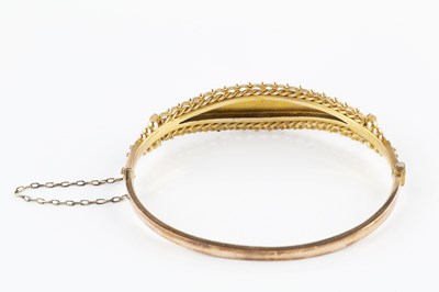Lot 40 - An Edwardian gem set bangle, of hinged oval...