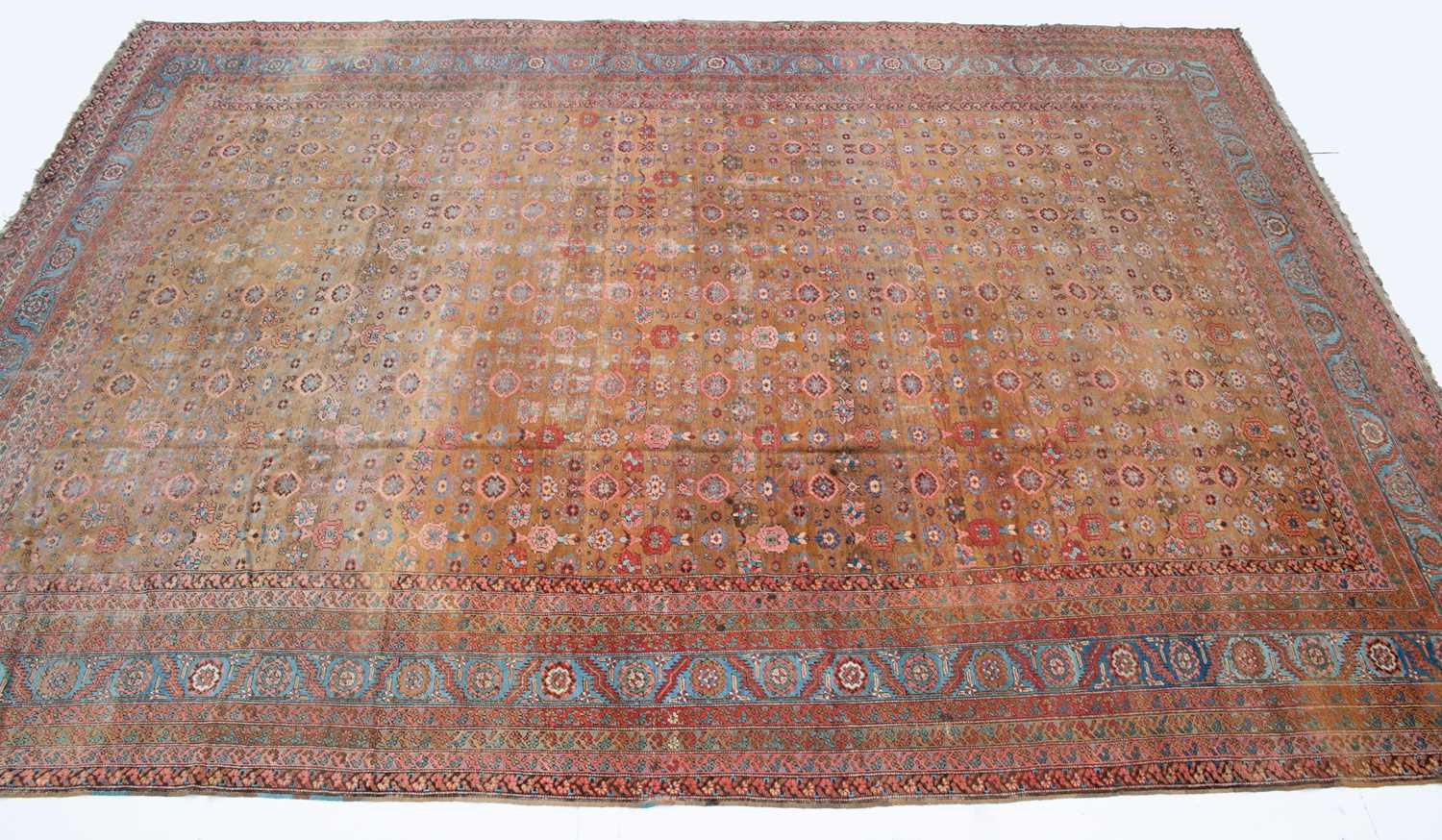 1040 - A Persian light brown ground carpet