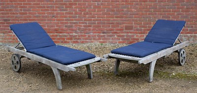 Lot 1101 - A pair of teak wooden slatted sun loungers