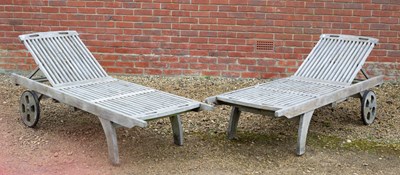 Lot 1101 - A pair of teak wooden slatted sun loungers
