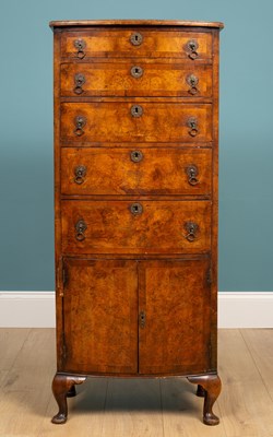 Lot 303 - A reproduction figured walnut and crossbanded bow fronted narrow chest of drawers