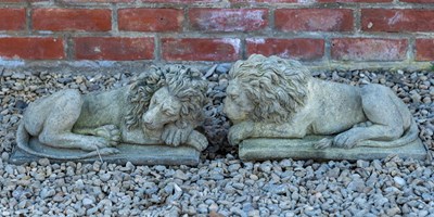 Lot 1183 - A pair of cast reconstituted stone recumbent lions