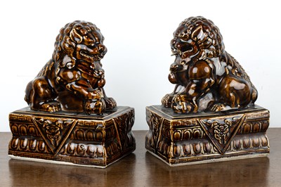 Lot 176 - Pair of treacle glazed temple dogs Chinese...