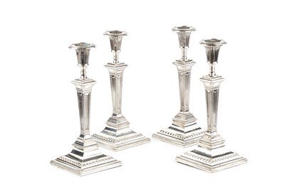 Lot 565 - A set of four George III silver candlesticks,...