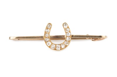 Lot 15 - A diamond horseshoe bar brooch, highlighted...