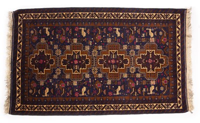 Lot 234 - A blue and brown ground Afghan rug decorated...