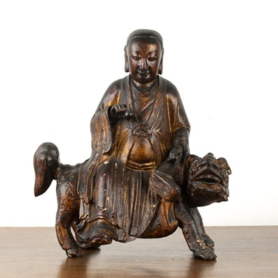 Lot 389 - Carved giltwood Lohan seated on a temple dog...