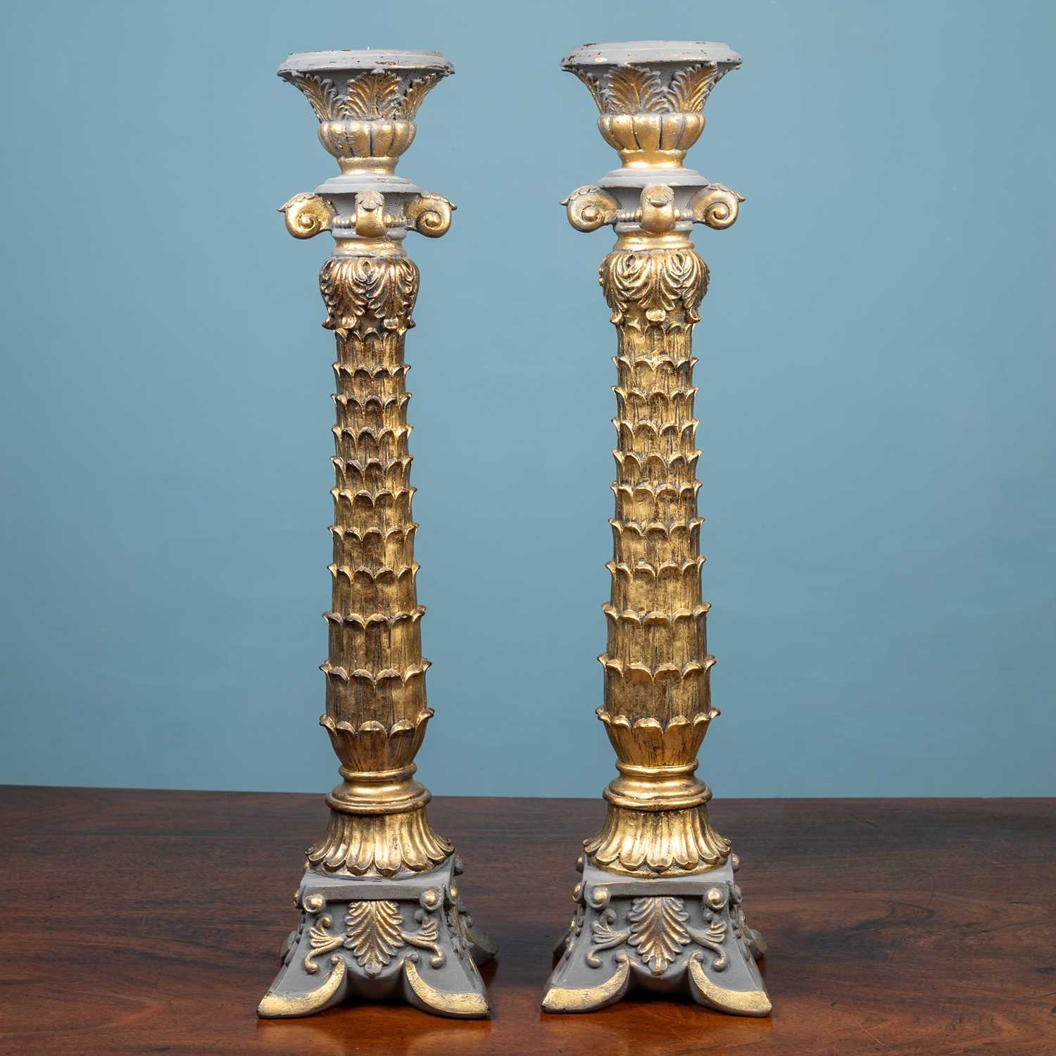Lot 63 - A pair of tall ornately carved gilt candlestick holders