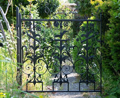 Lot 1299 - An antique scroll and flowerhead decorated wrought iron garden gate