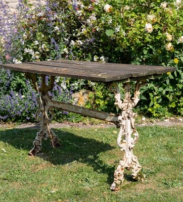 Lot 1291 - A Victorian cast iron conservatory table base with a later wooden plank top