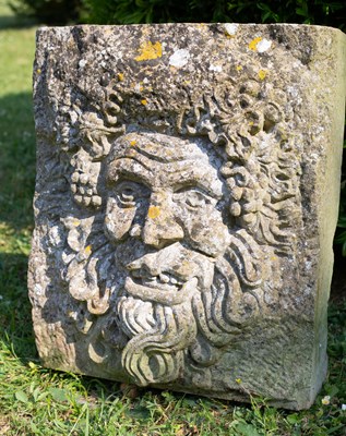 Lot 1256 - A carved stone Green Man mask panel; together with a piece of stone with a motto carved into it