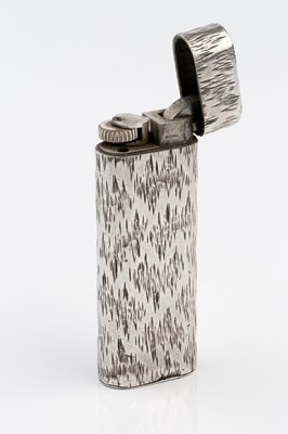Lot 506 - A silver lighter by Cartier, the rounded...