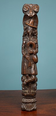 Lot 460 - An antique carved oak element depicting a full length figure playing the bagpipes