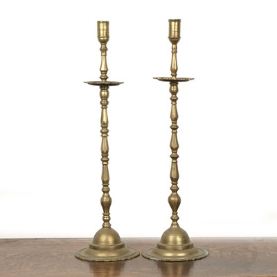 Lot 419 - Pair of brass altar candlesticks on knopped...