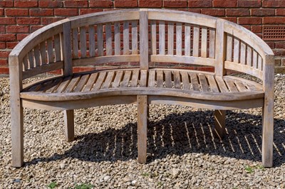 Lot 1288 - A teak curving garden bench witha matching kidney shaped low table