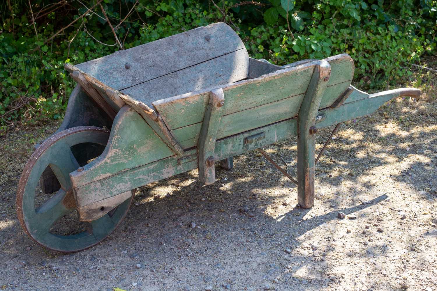 Lot 1304 - An old wooden green painted garden wheelbarrow