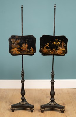 Lot 552 - A pair of Edwardian black lacquered pole screens