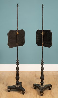 Lot 552 - A pair of Edwardian black lacquered pole screens