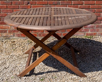 Lot 1262 - A circular teak garden dining table, a set of four 'wicker' armchairs and a parasol