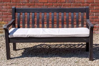 Lot 1228 - A dark stained wooden garden bench complete with a cream coloured cushion