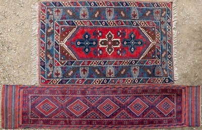 Lot 1065 - A red and blue ground Oriental rug; together with a blue ground runner