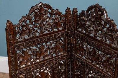 Lot 566 - An Anglo-Indian carved hardwood folding table together with a matching three-fold small screen