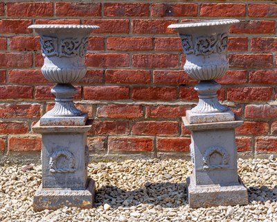 Lot 1283 - A pair of small cast iron grey painted urns