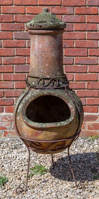 Lot 1215 - A Mexican terracotta chiminea and cover on a wrought iron stand