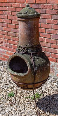 Lot 1215 - A Mexican terracotta chiminea and cover on a wrought iron stand