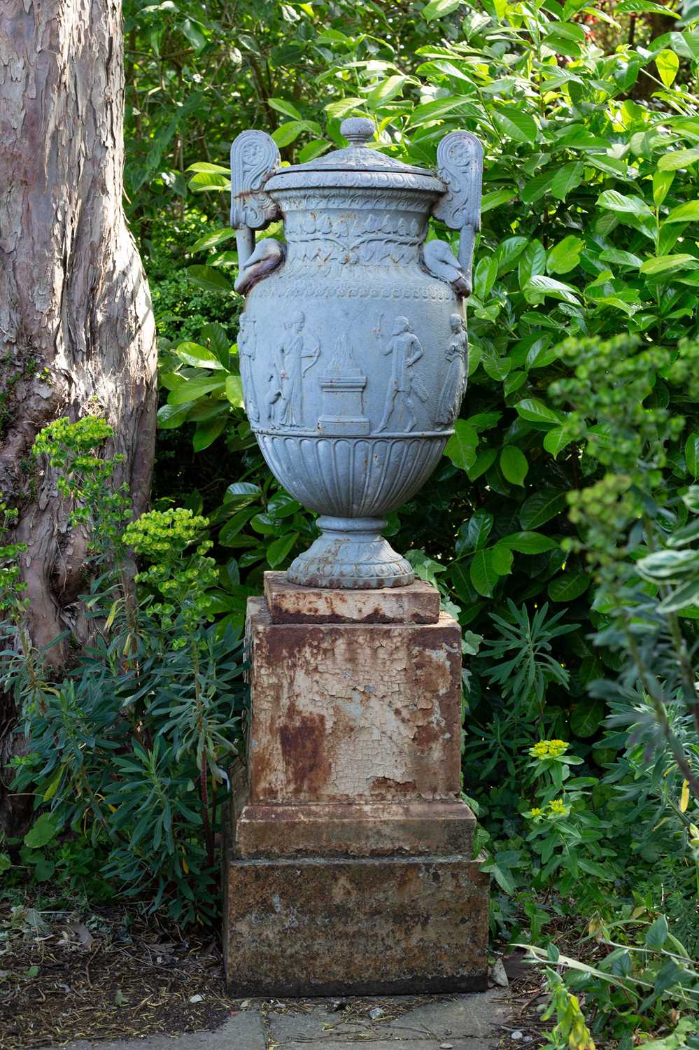 Lot 1357 - A Victorian cast iron urn and cover on a stepped plinth base after the Sosibios vase