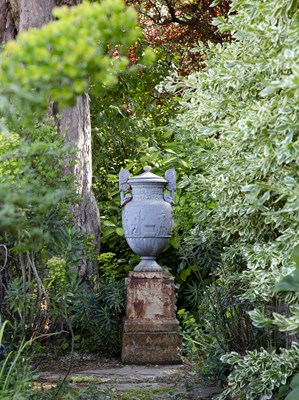 Lot 1357 - A Victorian cast iron urn and cover on a stepped plinth base after the Sosibios vase