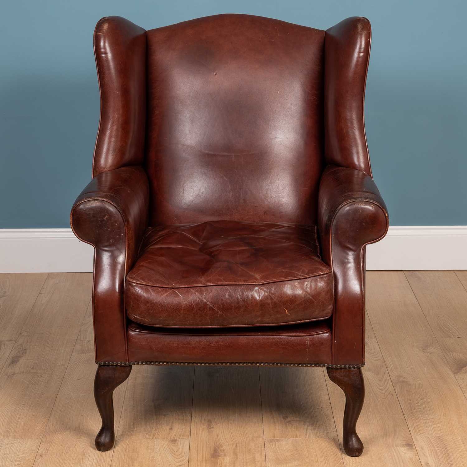 Lot 46 - A contemporary marron leather upholstered wing back armchair