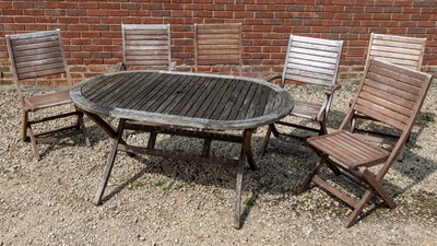 Lot 1266 - A folding teak garden dining table with a set of six matching folding chairs