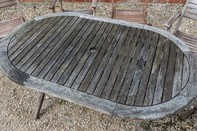 Lot 1266 - A folding teak garden dining table with a set of six matching folding chairs