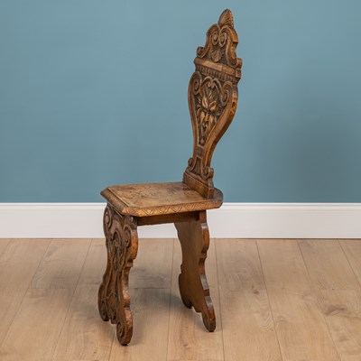 Lot 562 - A heavily carved Sgabello style Italian walnut hall chair