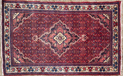 Lot 1077 - An Oriental red ground rug