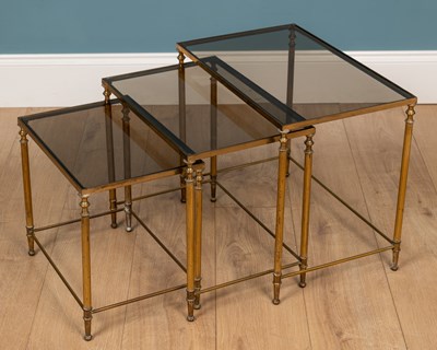 Lot 307 - A nest of brass tables with glass tops