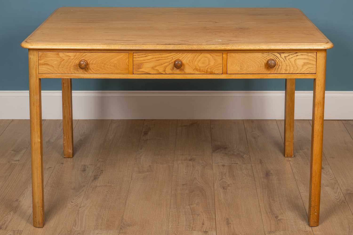 Lot 143 - A pine veneered kitchen table with three...