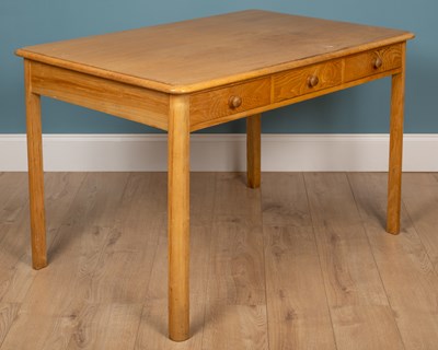 Lot 143 - A pine veneered kitchen table with three...