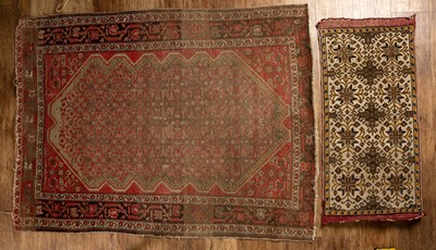 Lot 55 - Red ground rug with a shaped central panel,...