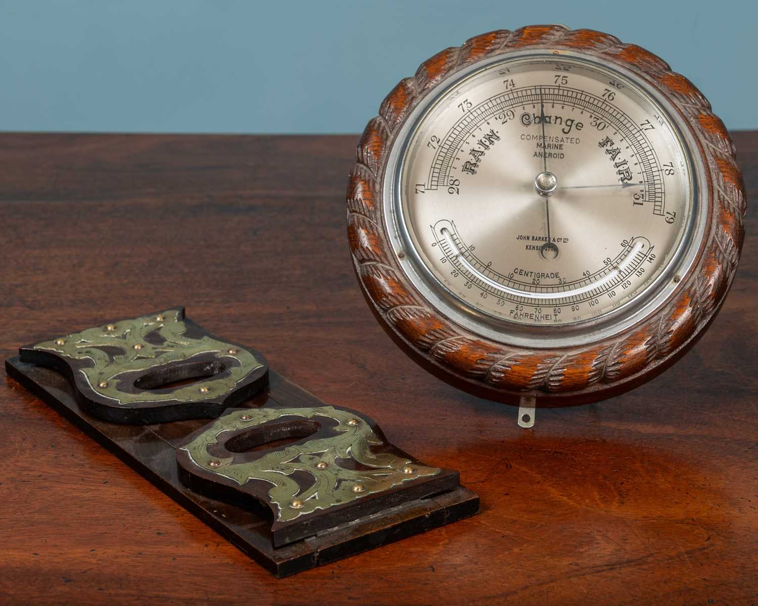 Lot 64 - A compensated marine aneroid barometer together with an Arts & Crafts mahogany adjustable book slide