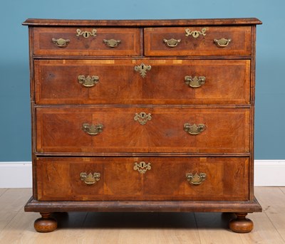 Lot 415 - A Georgian walnut cottage cut chest of two short and three long drawers