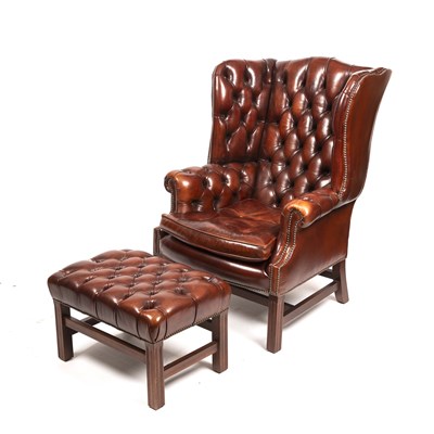 Lot 238 - A Georgian style wing back armchair with brown...