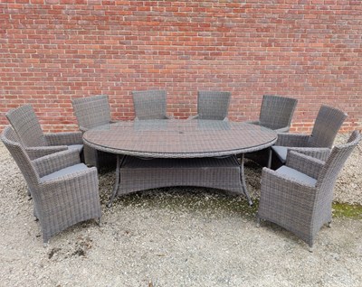 Lot 575 - An oval glass topped garden table together with a set of eight faux wicker chairs