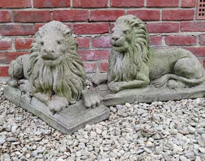 Lot 509 - A pair of cast reconstituted stone seated lions on plinths