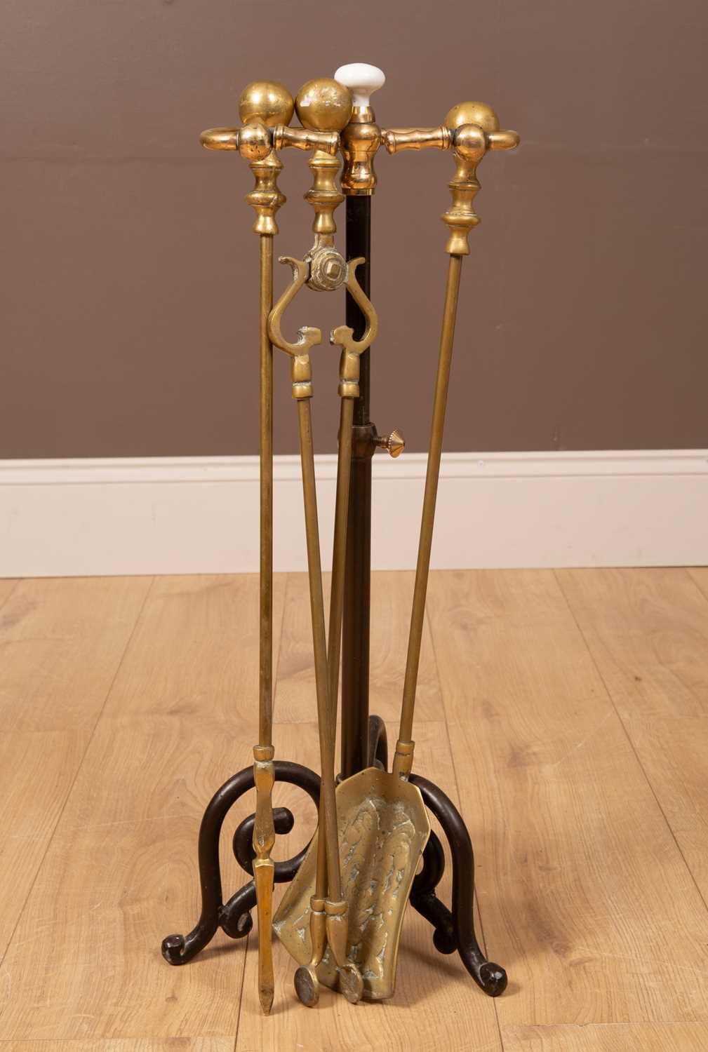 Lot 223 - A set of brass fire irons in a stand