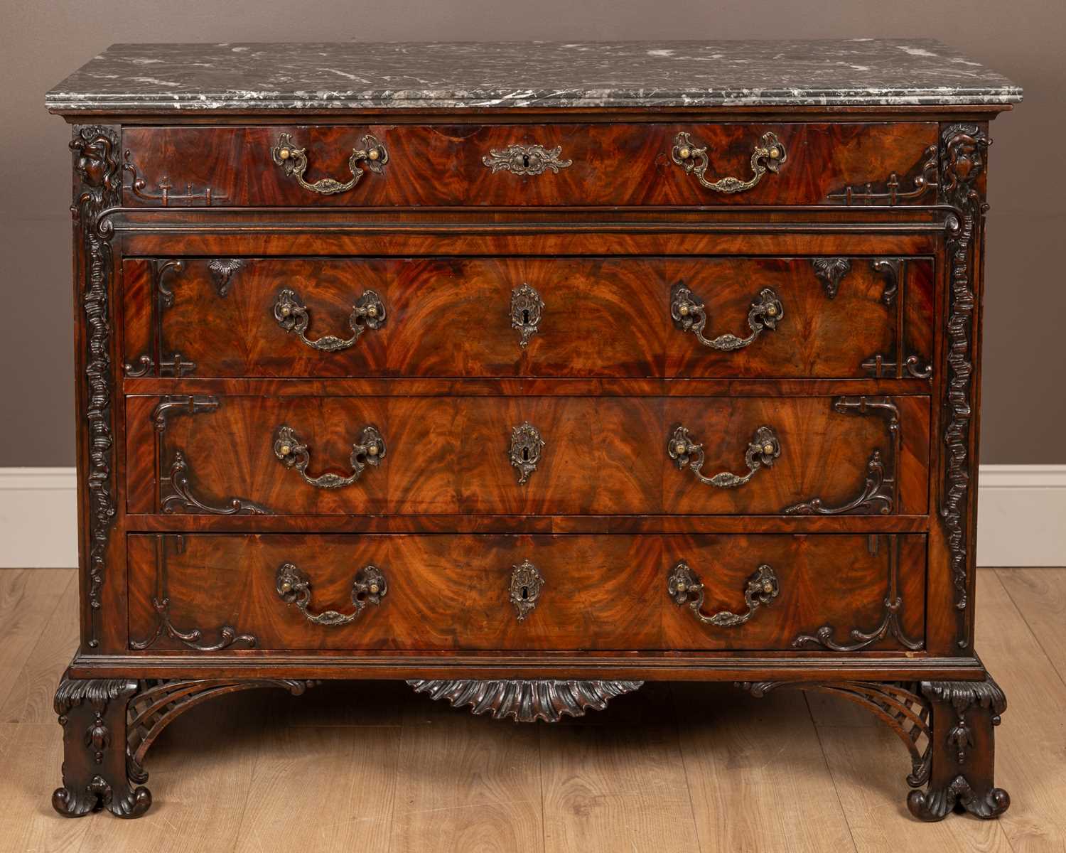 Lot 78 - An 18th century style Irish mahogany chest of drawers with a marble top in the Chippendale style