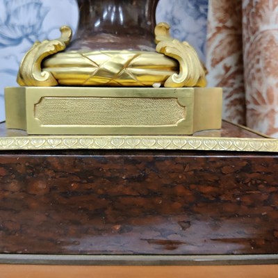 Lot 158 - A pair of French Empire style rouge marble lidded urns