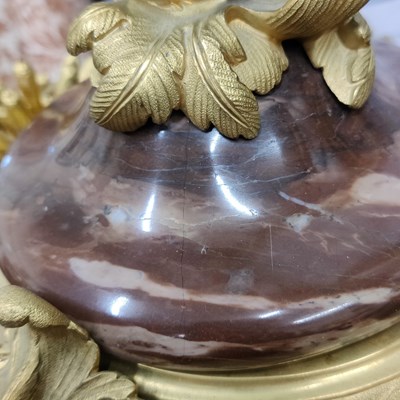 Lot 158 - A pair of French Empire style rouge marble lidded urns